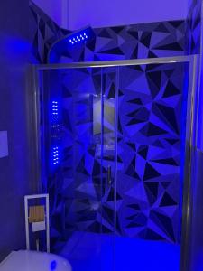 La salle de bains est pourvue d'une douche en verre avec éclairage bleu. dans l'établissement B&B MANFREDI, à Foggia
