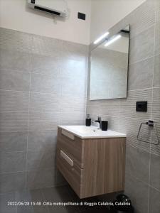 La salle de bains est pourvue d'un lavabo et d'un miroir. dans l'établissement nonna rosa, à Reggio de Calabre
