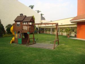 a play house with a swing in a yard at Hotel Argento in Cuernavaca