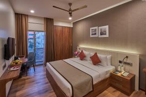 a hotel room with a large bed and a desk at Regenta Inn Grand-ORR, Mahadevapura in Bangalore