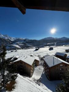 a winter view of a resort in the snow at Hotel Péz Ault in Disentis