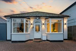 a small house with a white door and windows at Evergreen Lodge-Wyndale-4BR WParking BHam NEC in Birmingham
