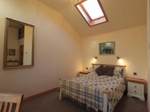 1 dormitorio con cama y espejo en Swallow cottage, Over Kellet en Over Kellet