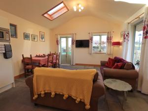 a living room with two couches and a dining room at Swallow cottage, Over Kellet in Over Kellet