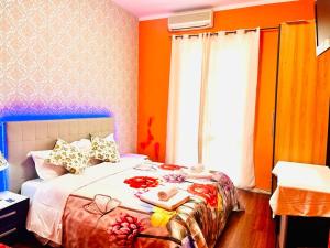 a bedroom with a bed with orange walls and a window at Green Guesthouse in Rome
