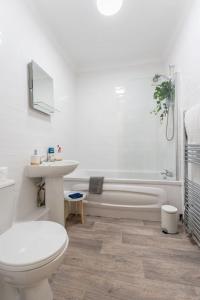 a bathroom with a toilet and a tub and a sink at Evergreen Lodge-Wyndale-4BR WParking BHam NEC in Birmingham