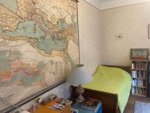 a bedroom with a map on the wall and a lamp at Private rooms in calm district close to center in Strasbourg