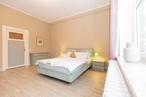 1 dormitorio con 1 cama con sábanas blancas y 2 lámparas en Alter Fischereihafen 52 en Cuxhaven