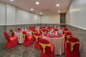 a room with red and yellow tables and chairs at Regenta Inn Grand-ORR, Mahadevapura in Bangalore