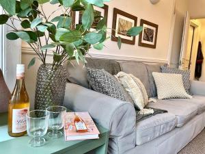 a living room with a couch and a table with a plant at Nomi Homes*Exeter*City*Centre*Uni*Chiefs*Beaches in Exeter +15 photos