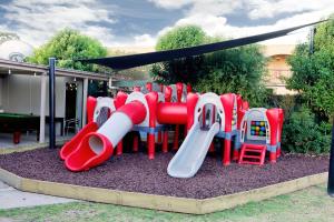 a playground with a red and white slide at Lake Mulwala Hotel in Mulwala