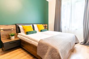 a bedroom with a bed with yellow and green pillows at Loft Apart in Iława