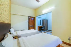 a hotel room with two beds and a desk at Hotel Executive in Lucknow