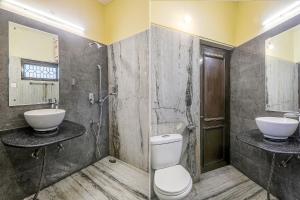 a bathroom with a toilet and a sink and a shower at Hotel Executive in Lucknow