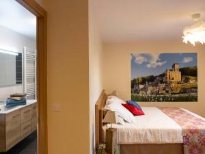 1 dormitorio con 1 cama con una pintura en la pared en Gîte La Roque-Gageac, 5 pièces, 8 personnes - FR-1-616-1, en La Roque-Gageac
