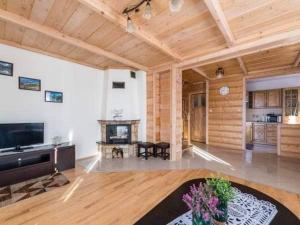 uma ampla sala de estar com lareira e tectos em madeira em Domki u Jasia em Zakopane