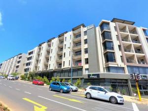 a large apartment building with cars parked in front of it at URBAN PARK UMHLANGA J001 in Durban
