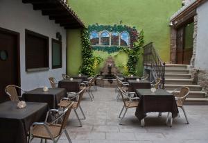 un restaurante con mesas y sillas y una pared verde en Hotel Palacio del Obispo, en Graus