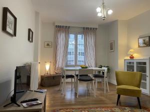 sala de estar con mesa, sillas y ventana en Appartement Moulins, 2 pièces, 2 personnes - FR-1-489-398, en Moulins