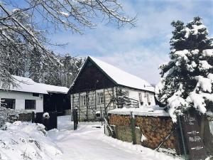 a house in the snow with a fence at Chalupa Skála 1827 in Skála