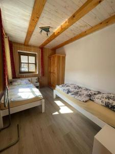 a bedroom with two beds and a wooden ceiling at Lukashof in Waldmünchen