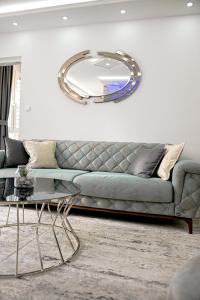 a living room with a couch and a large mirror at Fontana apartmani FREE parking in Tuzla