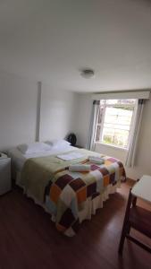 1 dormitorio con 1 cama con una manta colorida en Pousada Vale do Garimpeiro, en Diamantina