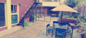 une terrasse avec une table, des chaises et un parasol dans l'établissement Sentir Indiano, à Valeria del Mar
