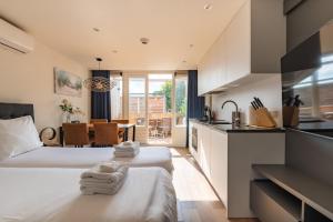 two beds in a room with a kitchen at Stylish apartments in the heart of Breda city center in Breda