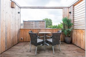 a patio with chairs and a table on a wooden deck at Stylish apartments in the heart of Breda city center in Breda