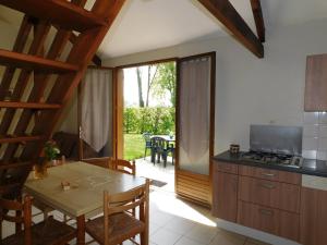 a kitchen with a table and a dining room with a patio at Village de Gîtes de La Chesnaie in Saint-Denis-du-Maine