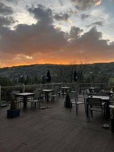 a group of tables and chairs with a sunset in the background at Lowena Lodge in Troutbeck