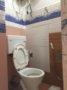a bathroom with a toilet with the lid up at Swastika Homestay and Travels Kurseong Bazar Near HDFC Bank NH55 Road Kurseong in Kurseong