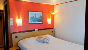 サロン・ド・プロヴァンスにあるカンパニール サロン ドゥ プロヴァンスのベッド1台と壁に2つの照明が備わるホテルルームです。