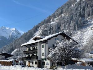 un edificio en la nieve frente a una montaña en Apart Matthias, en Mayrhofen