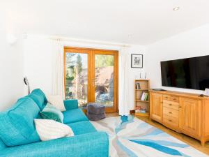 a living room with a blue couch and a television at Pass the Keys Rural Retreat in Rowington, Warwickshire in Warwick