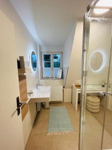 a bathroom with a sink and a glass shower at Maisonette-Fewo unter Reet, 50m zum Meer, Strandidyll Zingst in Zingst