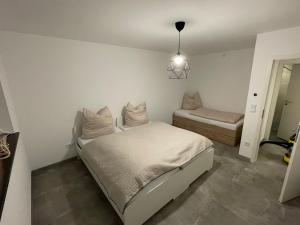 a white bedroom with a bed and a window at Ferienwohnung an der Papiermühle 