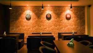 a restaurant with tables and chairs and a brick wall at Hotel Ballerina in Tinsukia