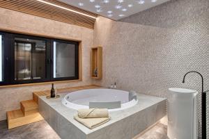 a large bathroom with a tub and a window at Galeria Jahorina Luxury Ski Apartments and Restaurant in Jahorina +82 photos