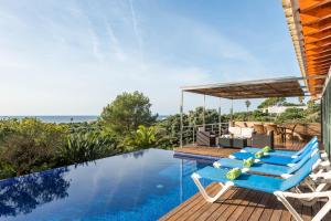 a house with a swimming pool with chairs and a swing at Villa Iris Torret by Escape Home in Sant Lluis