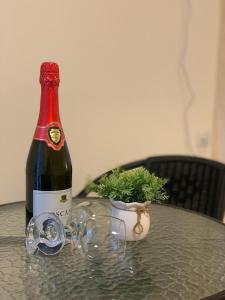 una bottiglia di vino seduta su un tavolo con un bicchiere di צימר מול פרדס 