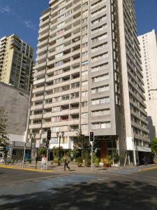 a large building on a city street with people walking in front of it at Apartamentos Santiago Centro R&M in Santiago