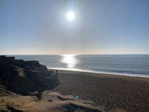 a beach with the sun rising over the ocean at The Captain's Retreat, Quiet 1 Bed Dog Friendly in Puncknowle