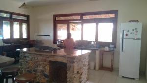 a woman standing at a stone counter in a kitchen at Casa Flamboaiã, Aluguel de Temporada, Guaibim, BA in Guaibim +13 photos