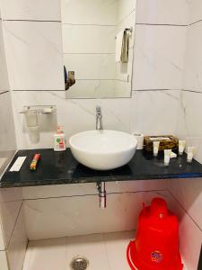 a bathroom with a white sink and a red fire hydrant at Pushkar Retreat Resort - The Nature and Mountain View Resort ,Pushkar in Pushkar