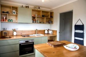 a kitchen with a wooden counter top and a wooden table at Periwinkle at Great Bay in Great Bay