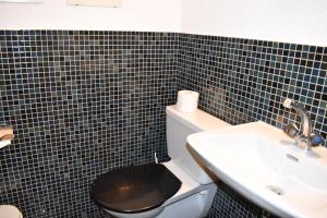 レンツァーハイデにあるCristallina (258 Me)のバスルーム(黒い蓋付きトイレ、シンク付)