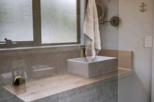 a bathroom with a sink and a mirror at Periwinkle at Great Bay in Great Bay