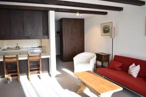 a living room with a red couch and a kitchen at Astoria (104 Mu) in Lenzerheide